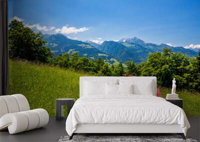 Two wooden red benches high in the Swiss Alps with great spring fresh bright green and blue panoramas. Hiking up the mountains in Switzerland is a blessing! Wall mural