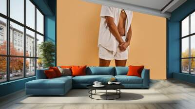 A bearded man with a white shirt and shorts walks confidently, exuding a sense of casual elegance and free-spirited charm. Wall mural