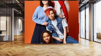 A diverse group of young friends, including a nonbinary person, posing stylishly for a group picture in a studio setting. Wall mural