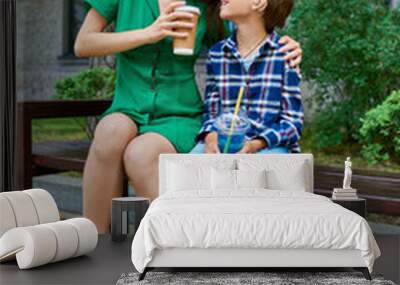 A mother shares a special moment with her hearing impaired son while seated. Wall mural