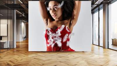 A young woman shows elegance and confidence in a vibrant red ensemble adorned with feathers. Wall mural