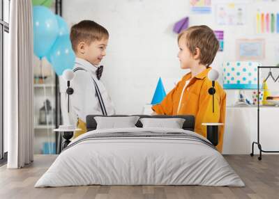 adorable preteen boys shaking hands during birthday party Wall mural