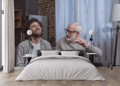 adult son and senior father talking and laughing at home Wall mural