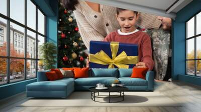 amazed boy opening christmas present near mother and father in camouflage, banner Wall mural