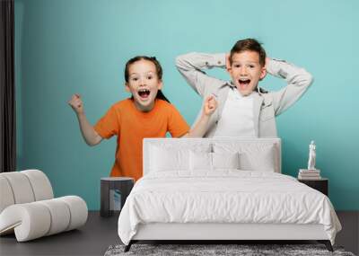 amazed children looking at camera isolated on blue. Wall mural