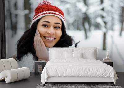 attractive african american woman touching cheek in winter forest Wall mural