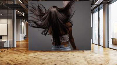 back view of brunette long haired woman isolated on black Wall mural