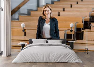 beautiful female university professor smiling and looking at camera in classroom Wall mural