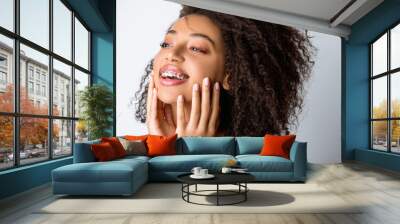 beautiful laughing african american girl with dental braces, isolated on grey Wall mural