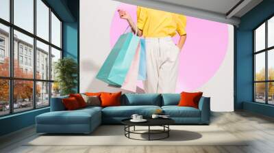 beautiful stylish girl looking at camera and holding colorful shopping bags on white with pink circle Wall mural