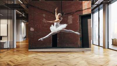 beautiful young ballerina jumping and dancing on urban street Wall mural