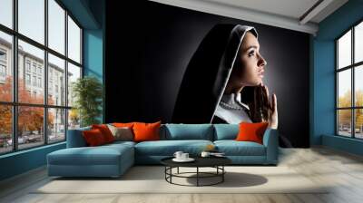 beautiful young nun looking up while praying with cross on grey Wall mural