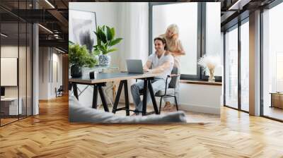 blonde woman massaging shoulders of boyfriend working from home with laptop, banner Wall mural