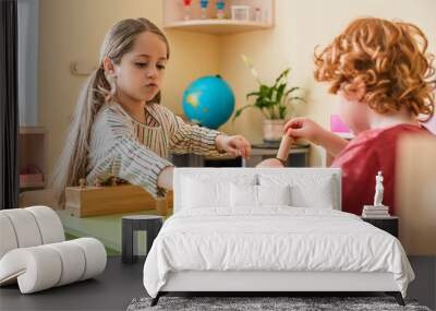 blurred redhead boy playing cognitive game with girl in montessori school Wall mural