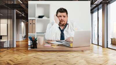 bored overweight businessman working with notepad and laptop in office Wall mural