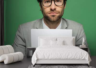 broadcaster in eyeglasses and grey suit holding blank paper isolated on green Wall mural