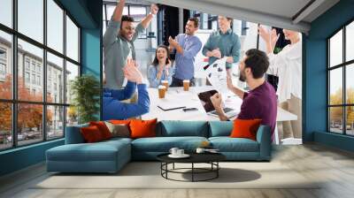 business team celebrating success together on workplace in office, young professional group concept Wall mural