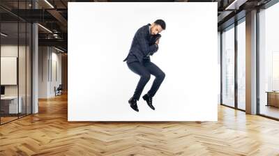 businessman in suit jumping while hugging briefcase on white. Wall mural