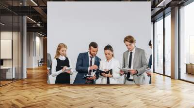 businesspeople in formal wear standing in row and writing something to notebooks during training in hub Wall mural