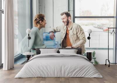 casual businessman and woman talking and laughing in loft office Wall mural