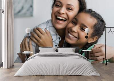 cheerful african american mother and teenage daughter hugging while looking at camera at home, banner Wall mural