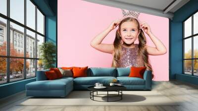 cheerful little girl in dress adjusting crown isolated on pink Wall mural