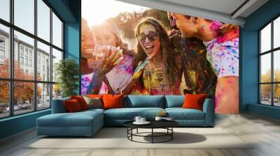 cheerful young multiethnic friends with colorful paint on clothes and bodies having fun together at  Wall mural