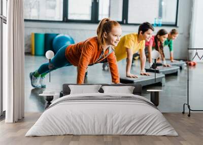 Children doing plank exercise with step platforms Wall mural