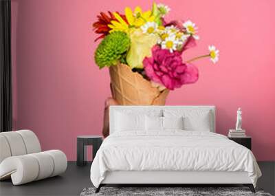 close-up partial view of woman holding ice cream cone with beautiful flowers isolated on pink Wall mural