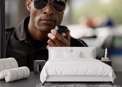 close-up portrait of african american police officer talking by walkie-talkie radio set Wall mural