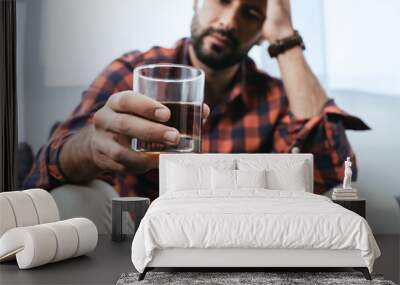 close-up shot of depressed young man with glass of whiskey Wall mural