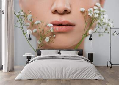 close up view of cropped female face near white gypsophila flowers isolated on grey. Wall mural