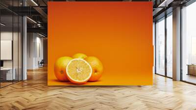 close-up view of fresh ripe whole and sliced oranges on orange background Wall mural