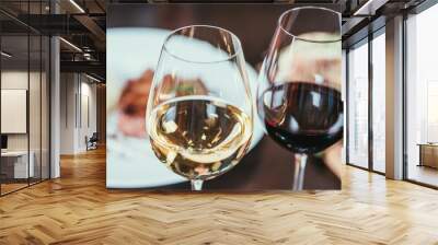 close-up view of two glasses with red and white wine on table in restaurant Wall mural