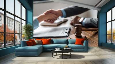 close-up view of wooden hammer and lawyer with client shaking hands behind Wall mural