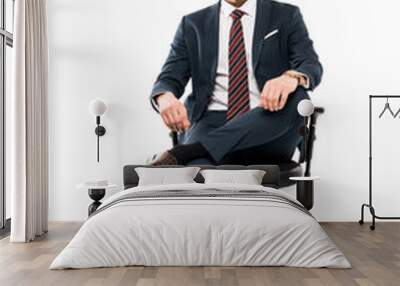 confident businessman sitting on chair and looking at camera isolated on white Wall mural