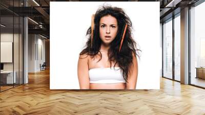 confused brunette woman with combs in wavy unruly hair isolated on white Wall mural