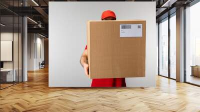 Courier in cap holding box with barcode and qr code on card isolated on grey Wall mural