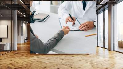 cropped image of patient giving id card to doctor to fill insurance claim form in clinic Wall mural