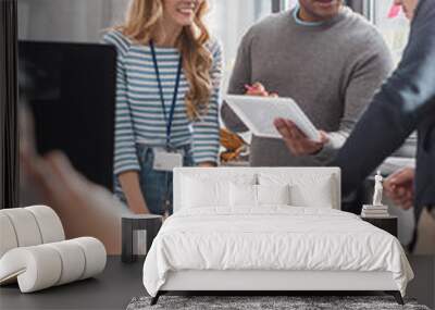 cropped image of people using tablet behind woman speaking on smatrphone at office Wall mural