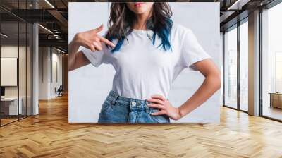 cropped image of young woman pointing by finger on empty white t-shirt Wall mural