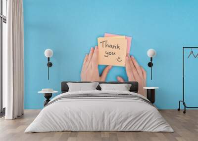 cropped person holding colorful sticky notes with thank you lettering isolated on blue background Wall mural