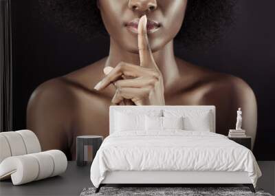 cropped shot of african american woman showing silence gesture isolated on black Wall mural