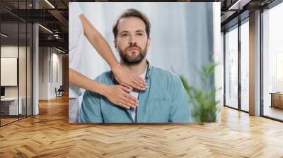 cropped shot of bearded man sitting and receiving reiki treatment on chest Wall mural