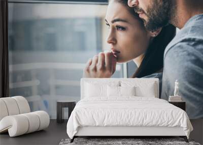 cropped shot of bearded man supporting sad young woman looking at window Wall mural