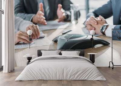 cropped shot of business people having conversation and using speakerphone at modern office Wall mural