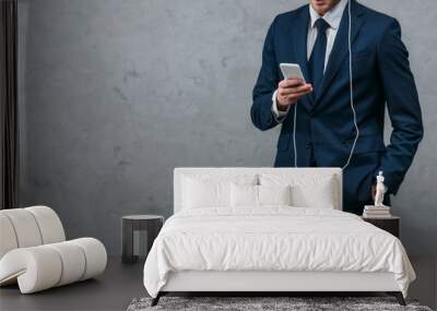 cropped shot of businessman listening music with headphones and smartphone Wall mural