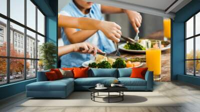 cropped shot of children eating healthy vegetables at wooden table Wall mural