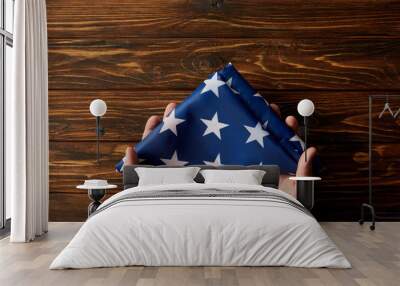 cropped shot of man holding folded united states flag on wooden background Wall mural