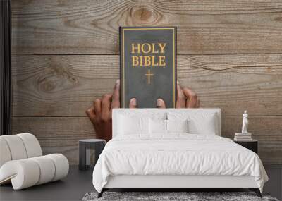 cropped shot of man holding holy bible on rustic wooden table Wall mural